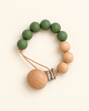 Load image into Gallery viewer, Emerald silicone and beechwood baby dummy clip on an ivory background
