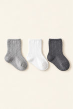Load image into Gallery viewer, Babynor ribbed organic baby socks in grey, white and charcoal on a warm ivory background
