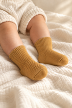 Load image into Gallery viewer, Baby wearing Babynor organic baby socks in Mustard

